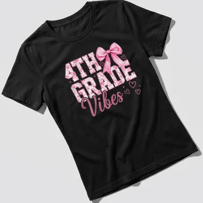 Illustration of a pink bow with hearts alongside the text 4TH GRADE Vibes — printed on a women's shirt