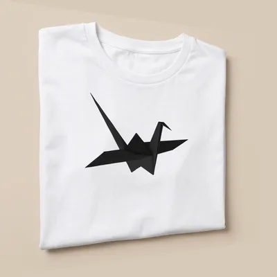 Minimalist black origami crane illustration on a — printed on a unisex t-shirt (angled view)
