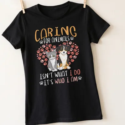 Illustrative design featuring a gray cat and dog with a heartfelt message on caring for animals — printed on a women's shirt