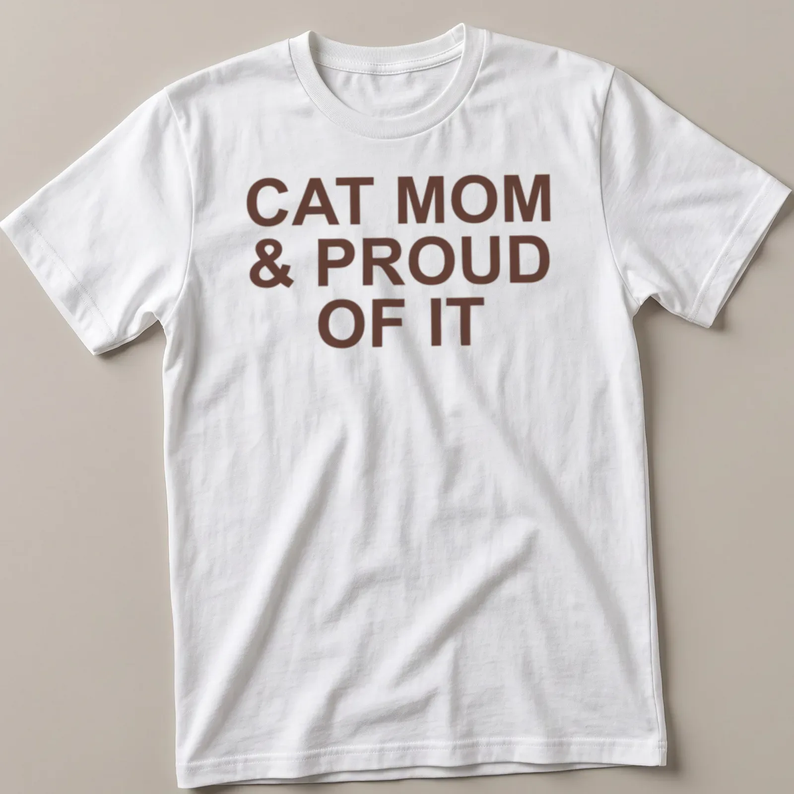 Bold typography of 'Cat Mom & Proud Of It' on a brown — printed on a unisex t-shirt