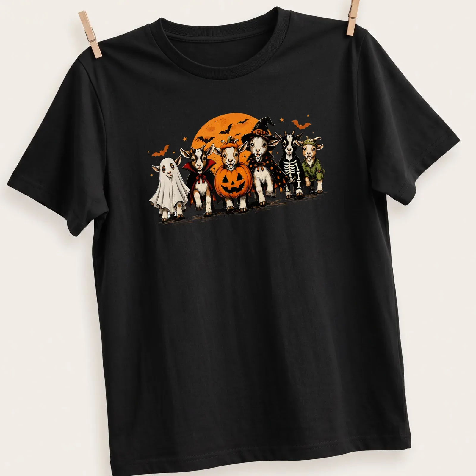 Cartoon-style t-shirt featuring goats in Halloween costumes, including a ghost — printed on a unisex t-shirt