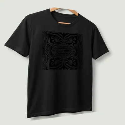 Black and white line art t-shirt featuring abstract tribal faces — printed on a unisex t-shirt (angled view)