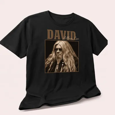 Vintage David Allan Coe t-shirt with distressed typography in brown and beige — printed on a unisex t-shirt (angled view)