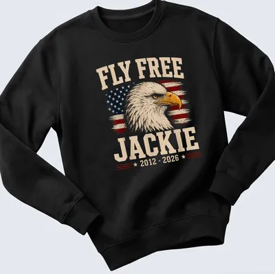 Eagle design with vintage distressed text 'Fly Free Jackie 2012 - 2026' on American flag background — printed on a unisex sweatshirt