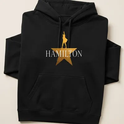 Gold star silhouette of a performer with the word Hamilton above in bold lettering — printed on a unisex hoodie