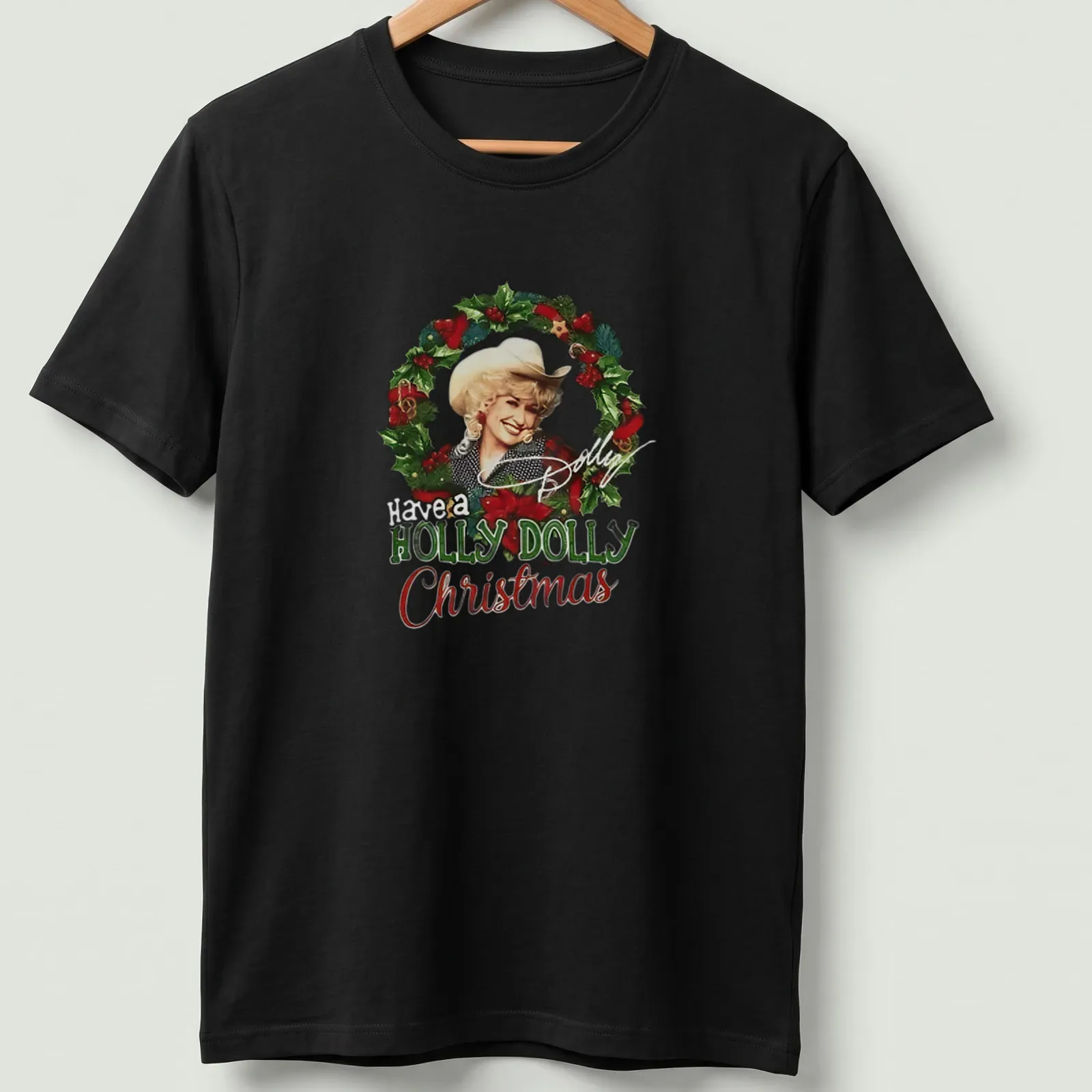 Festive illustration of Dolly Parton with the text Have a HOLLY DOLLY Christmas in green, red, white, and gold — printed on a unisex t-shirt
