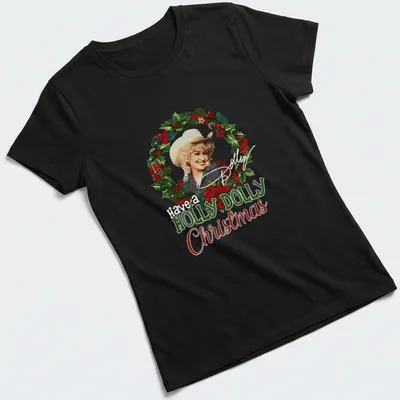 Festive illustration of Dolly Parton with the text Have a HOLLY DOLLY Christmas in green, red, white, and gold — printed on a women's shirt