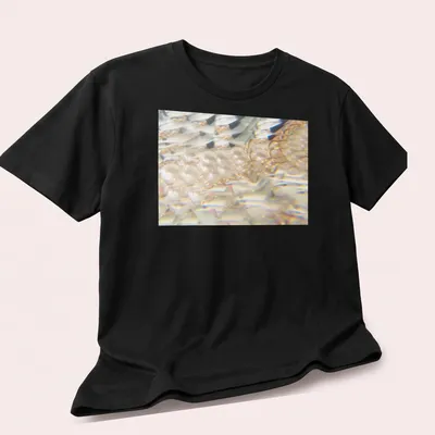 Iridescent jellyfish illustration in a prism effect with white, gold, and blue hues — printed on a unisex t-shirt (angled view)