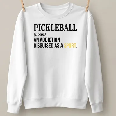Text-based design featuring the definition of pickleball as an addiction disguised as a sport — printed on a unisex sweatshirt
