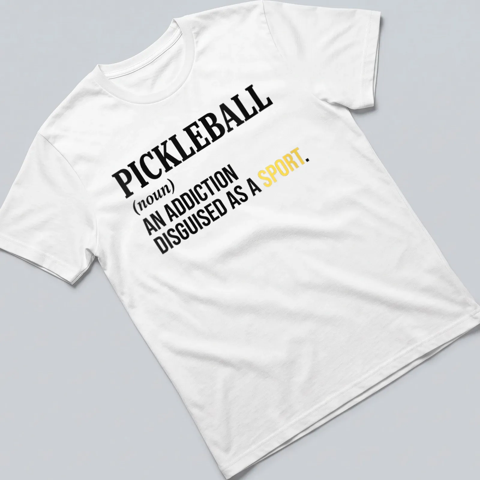 Text-based design featuring the definition of pickleball as an addiction disguised as a sport — printed on a unisex t-shirt