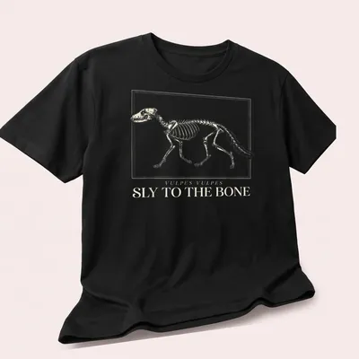 Scientific illustration of a fox skeleton with the text 'Vulpes Vulpes Sly To The Bone' — printed on a unisex t-shirt (angled view)