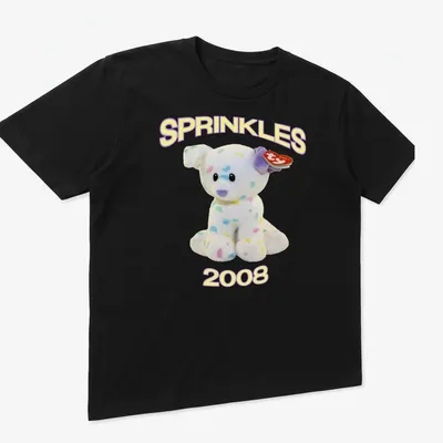 Cute cartoon plush dog with pastel colors and 'SPRINKLES 2008' text — printed on a unisex t-shirt (angled view)