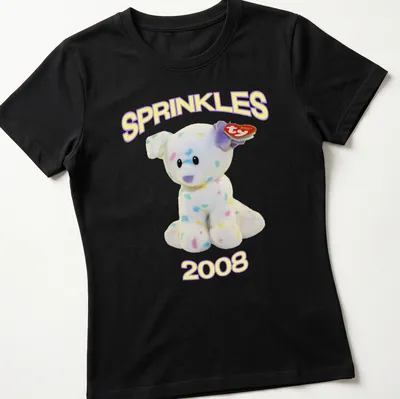 Cute cartoon plush dog with pastel colors and 'SPRINKLES 2008' text — printed on a women's shirt