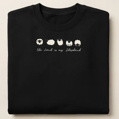 Minimalist sheep illustration with the text 'the Lord is my Shepherd' in cream and black. — printed on a unisex sweatshirt