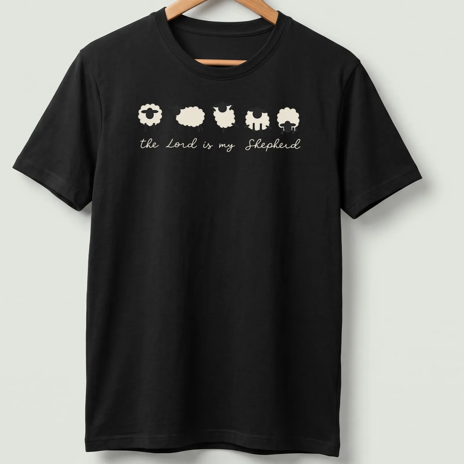 Minimalist sheep illustration with the text 'the Lord is my Shepherd' in cream and black. — printed on a unisex t-shirt
