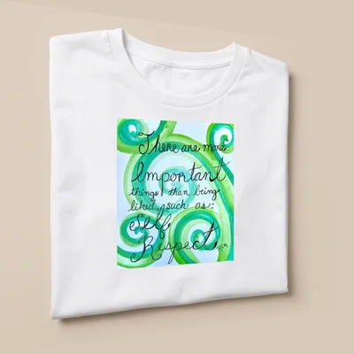 Handwritten motivational phrase on swirling green watercolor patterns — printed on a unisex t-shirt (angled view)