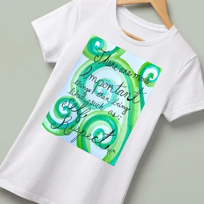 Handwritten motivational phrase on swirling green watercolor patterns — printed on a women's shirt