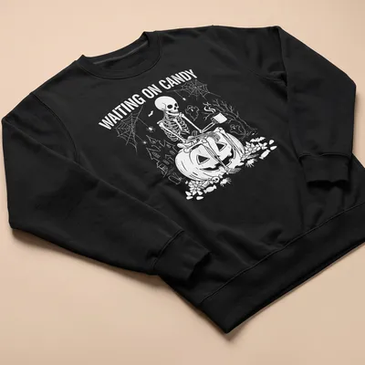 Spooky illustration of a skeleton on a pumpkin with text saying 'Waiting on Candy' — printed on a unisex sweatshirt
