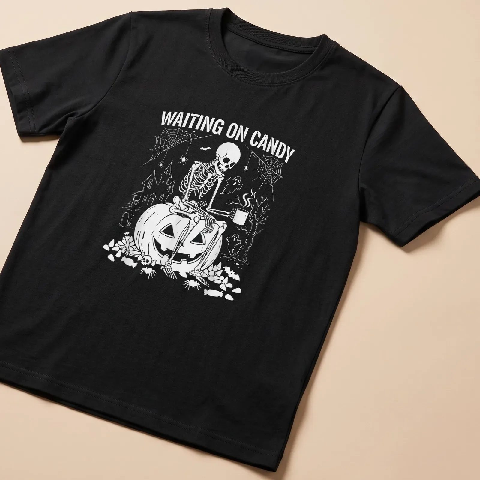 Spooky illustration of a skeleton on a pumpkin with text saying 'Waiting on Candy' — printed on a unisex t-shirt