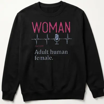 Distressed typography shirt featuring a microphone and heartbeat line with the text 'WOMAN noun Adult human female.' — printed on a unisex sweatshirt