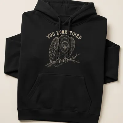 Vintage illustration of a tired vulture with the text 'YOU LOOK TIRED' in brown — printed on a unisex hoodie