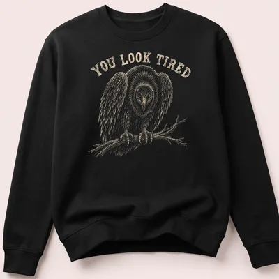 Vintage illustration of a tired vulture with the text 'YOU LOOK TIRED' in brown — printed on a unisex sweatshirt